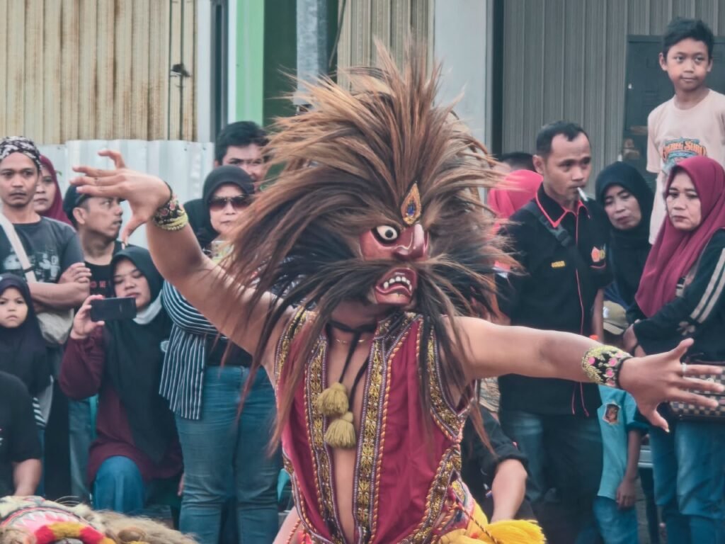 Penampil dengan karakter bertopeng menghidupkan suasana pertunjukan di tengah kerumunan penonton pada Tabuhan Gayeng Anniversary ke-3 Seni Reog Singo Ngremboko Patripurgo, Minggu, 9 Agustus 2026. DOK Emmanus